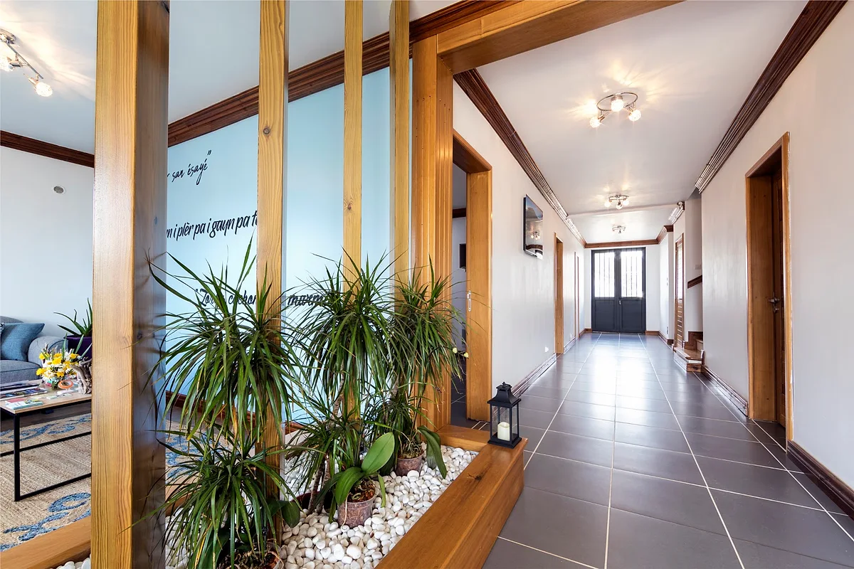 Le couloir des chambres, ses poteaux en bois et ses plantes