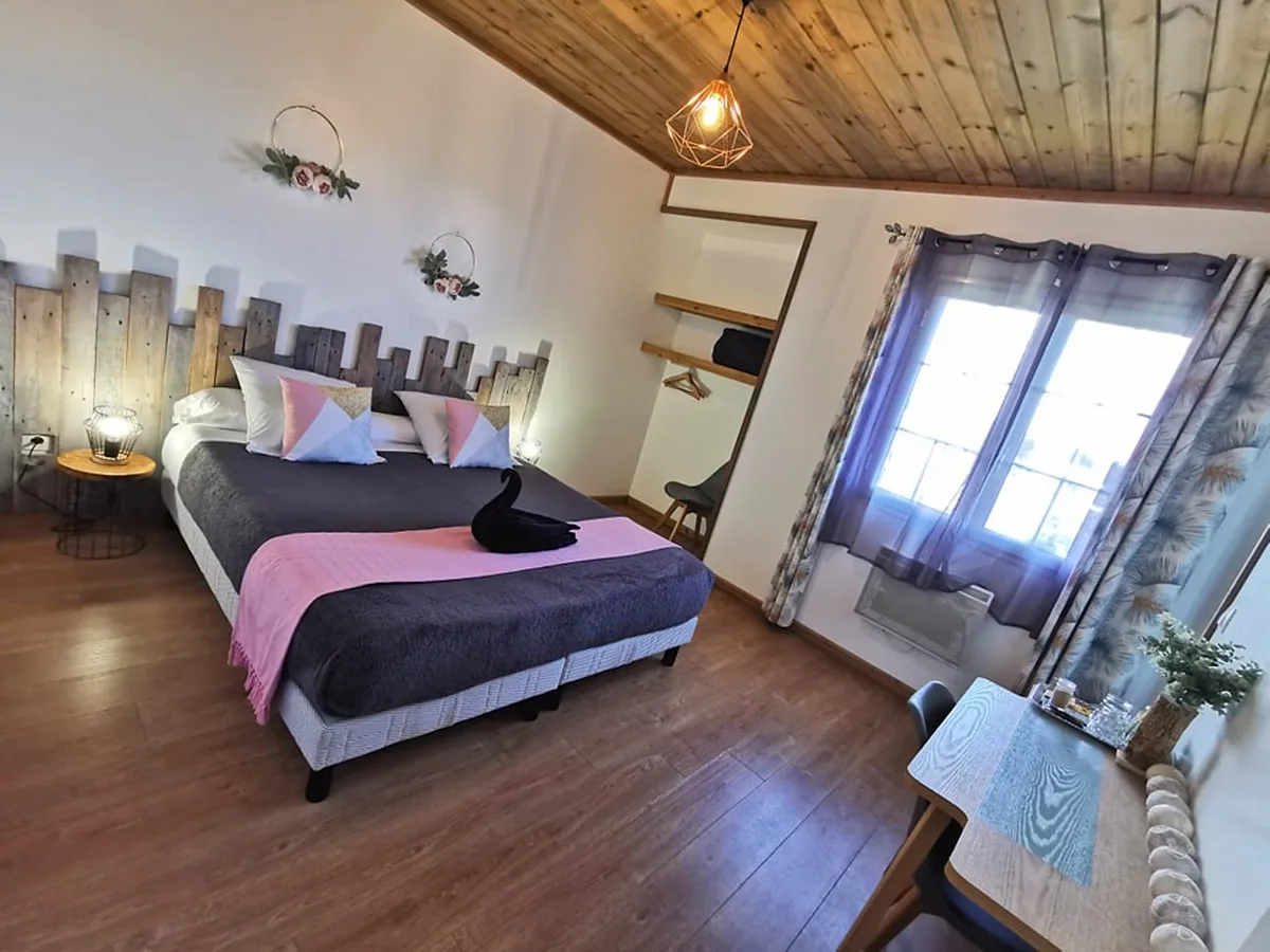 La chambre standard, son grand lit et sa tête de lit en planches